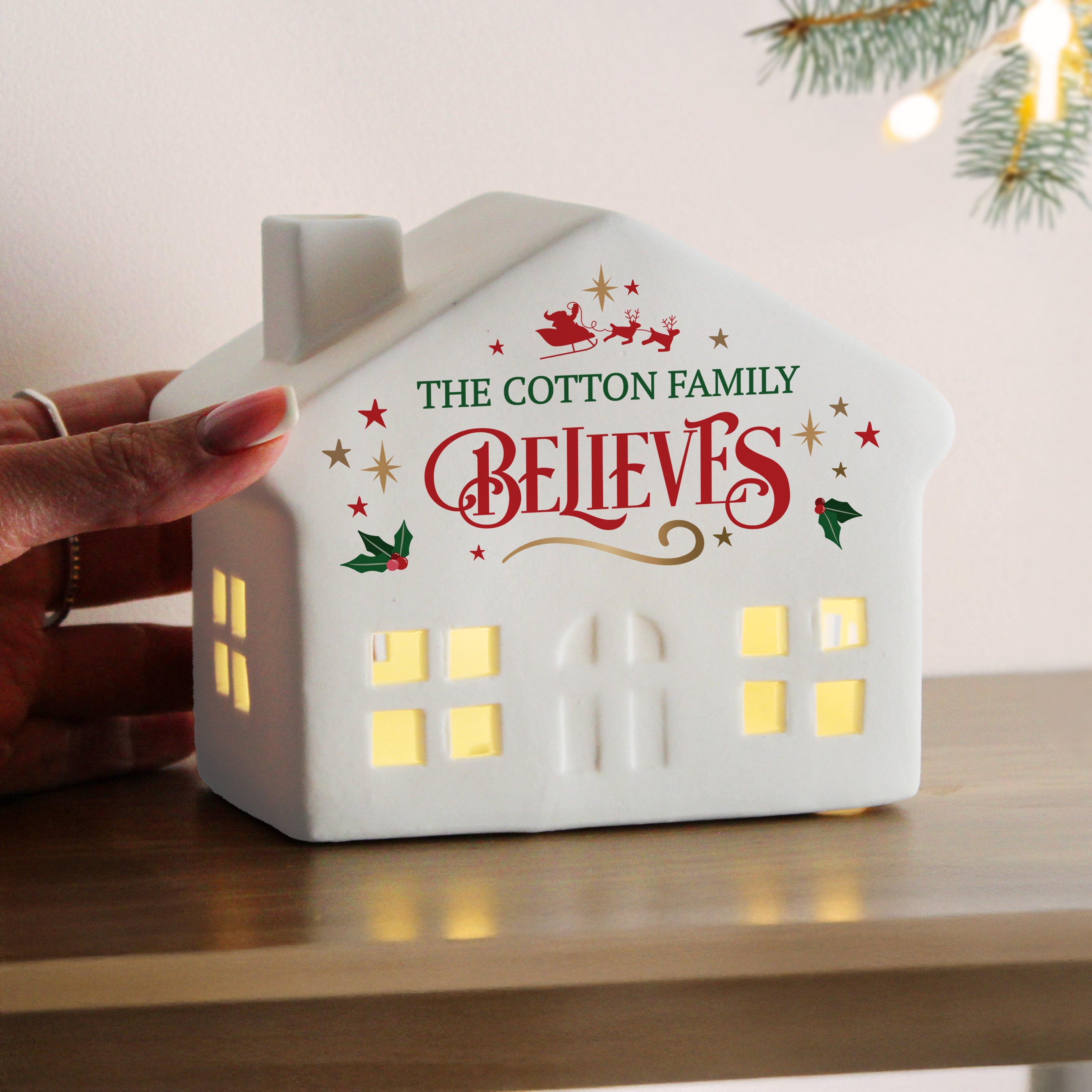 Detail of the personalized name and 'believes' engraving on the ceramic light-up house.