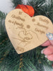 An engraved wooden Christmas keepsake for a new family, showing a heart-shaped design.