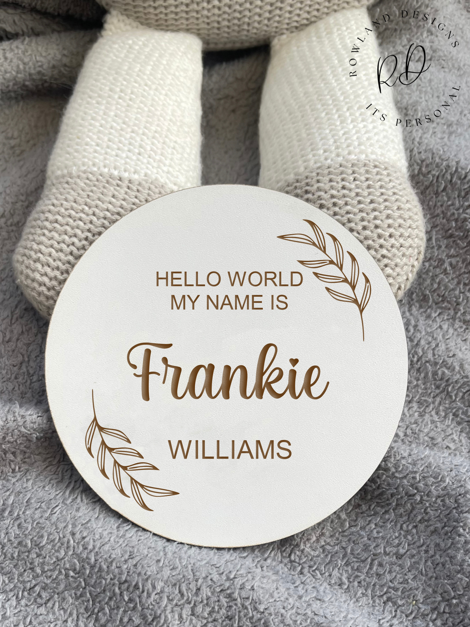 White MDF baby arrival sign featuring a minimalist leaf design and custom name.
