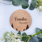 Natural beech wood baby reveal disc with tree engraving, perfect for nature-themed nursery photos.