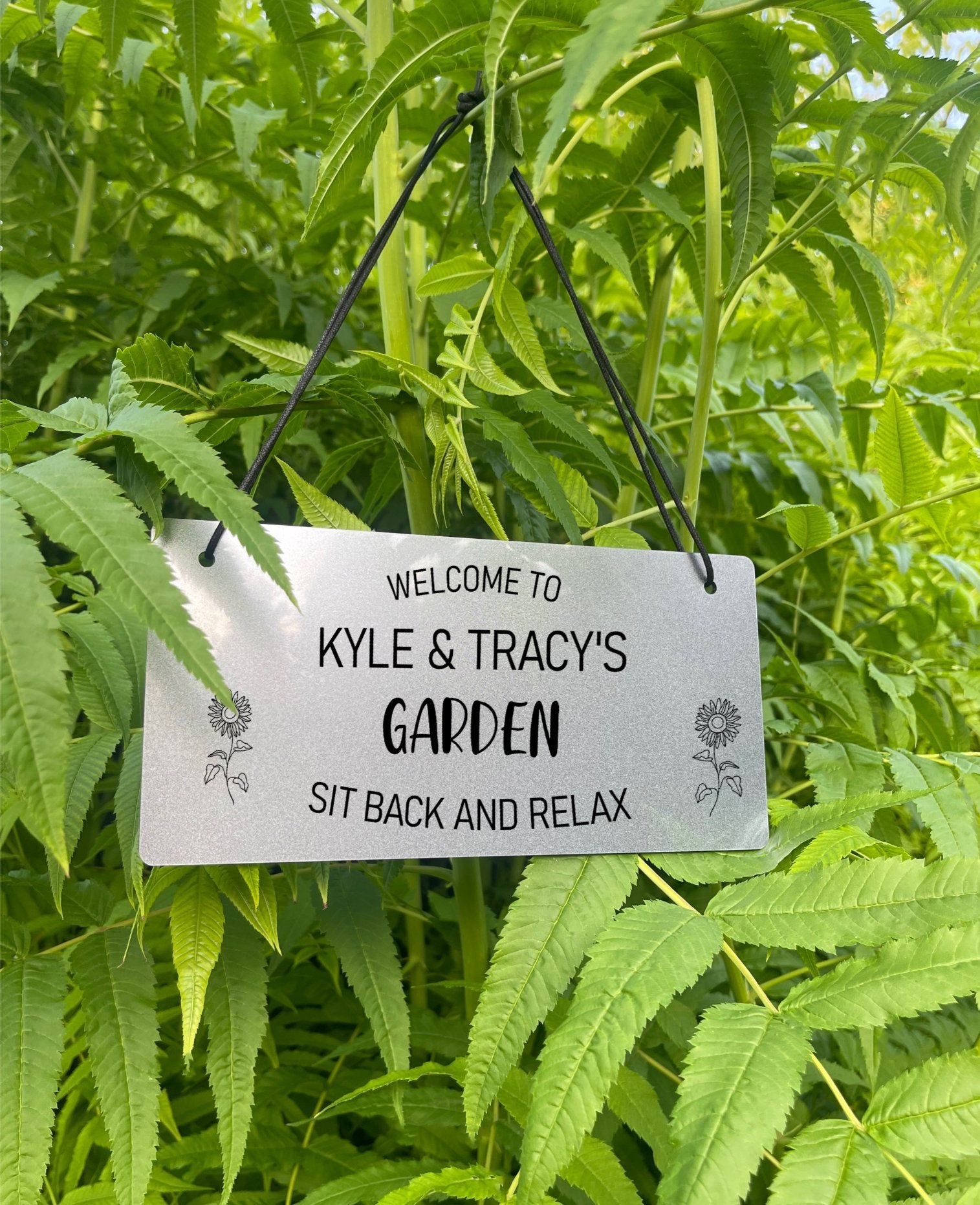 Silver personalised garden sign engraved with "Welcome to [Name’s] Garden" and sunflower details.