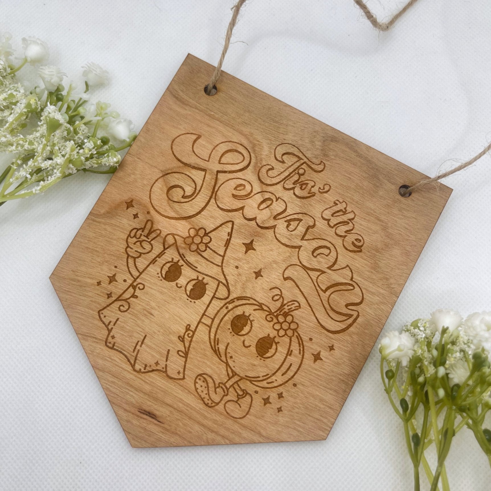 Halloween wooden hanging sign engraved with 'Tis' The Season', featuring a cute ghost and pumpkin design, made from natural wood with string.