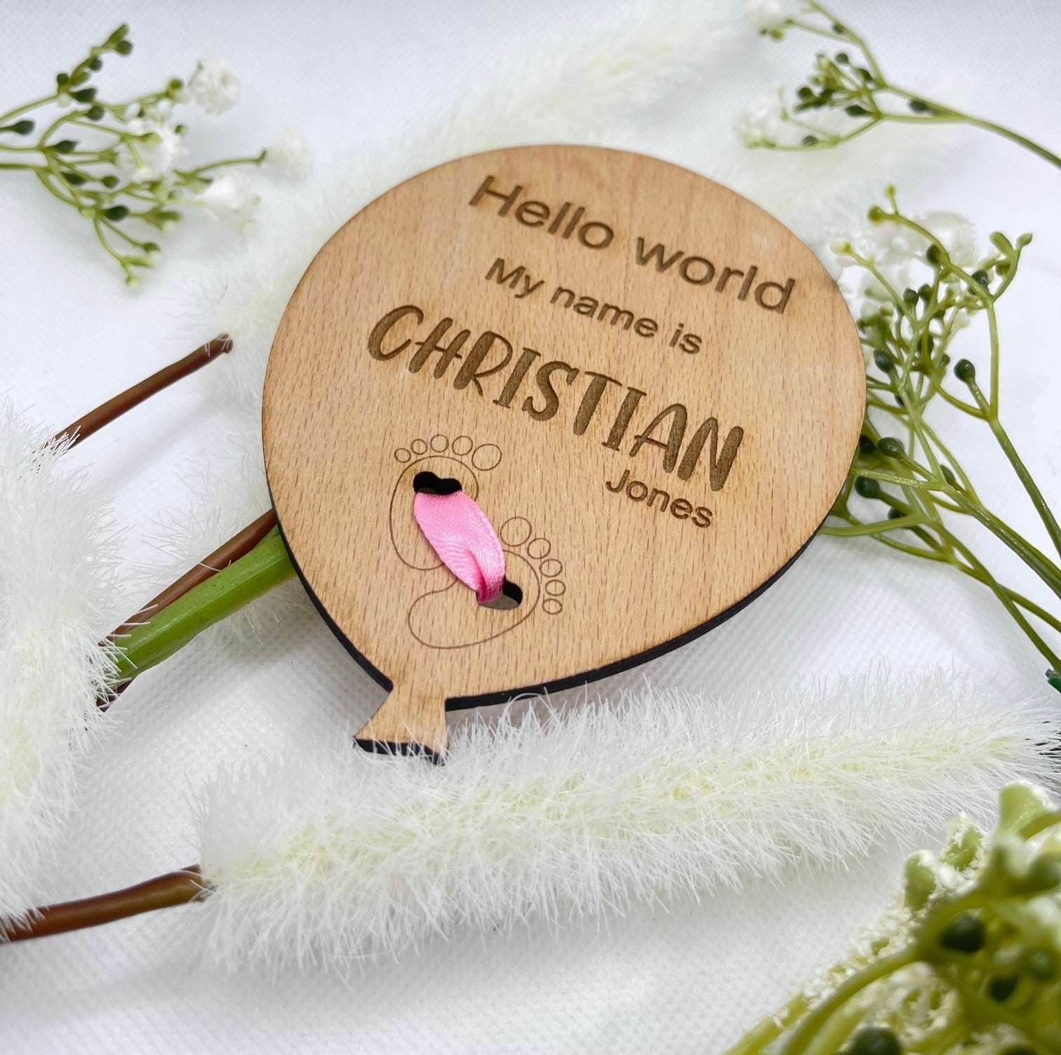 Personalised baby announcement plaque with feet design and pink ribbon.