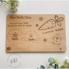 A wooden Christmas Eve board with spaces for Santa's treats and Rudolf's carrot.