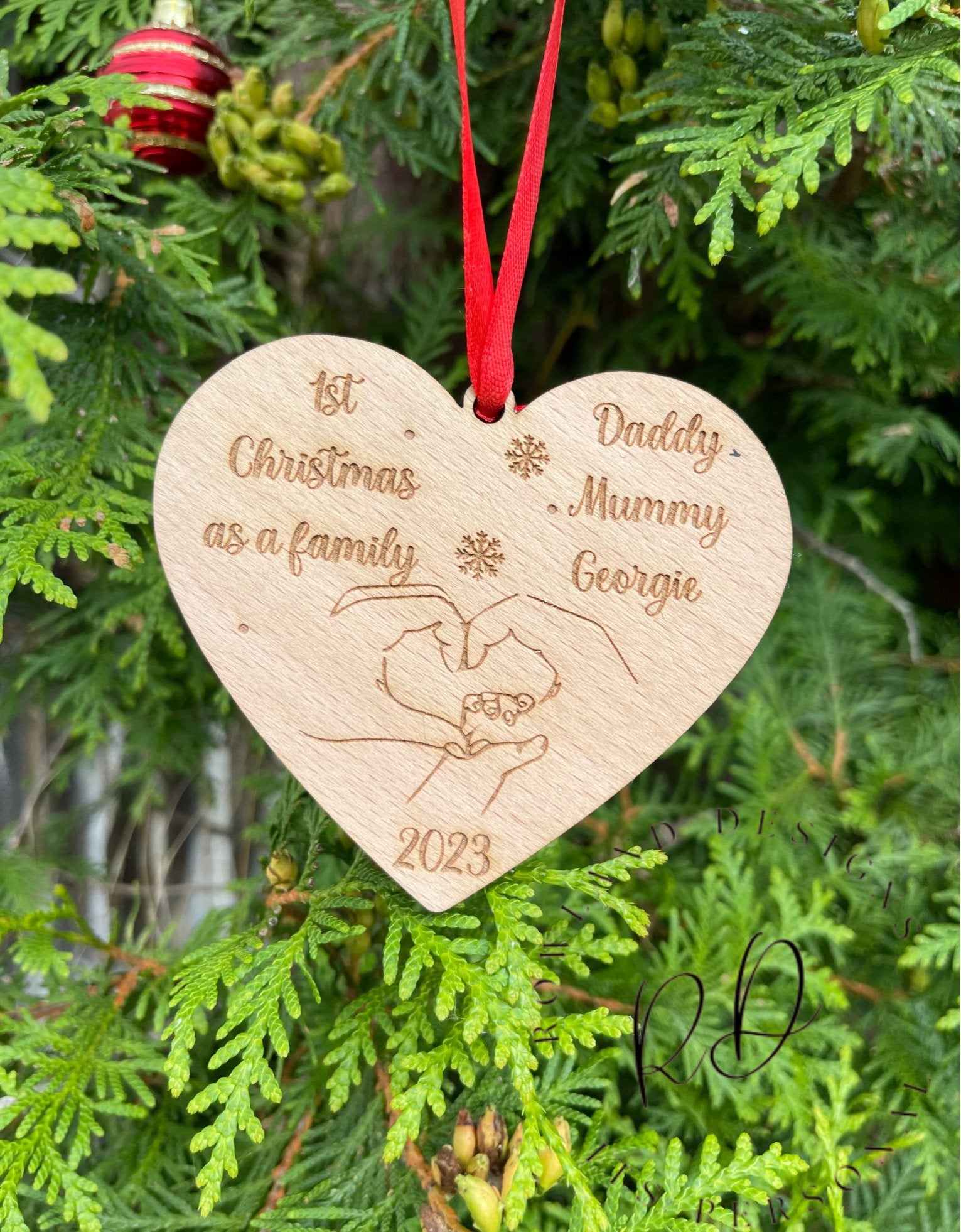  An engraved "1st Christmas as a Family" ornament with intertwined hands design.