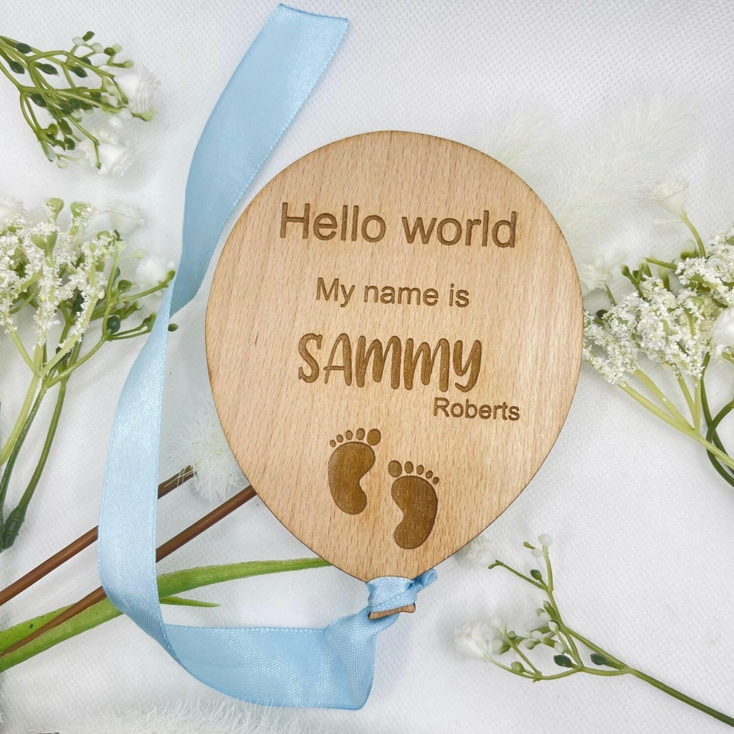 Close-up shot of the engraved feet design on a personalised baby announcement plaque.