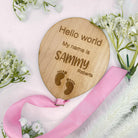 Handcrafted baby announcement plaque with a feet design and an elegant pink ribbon.