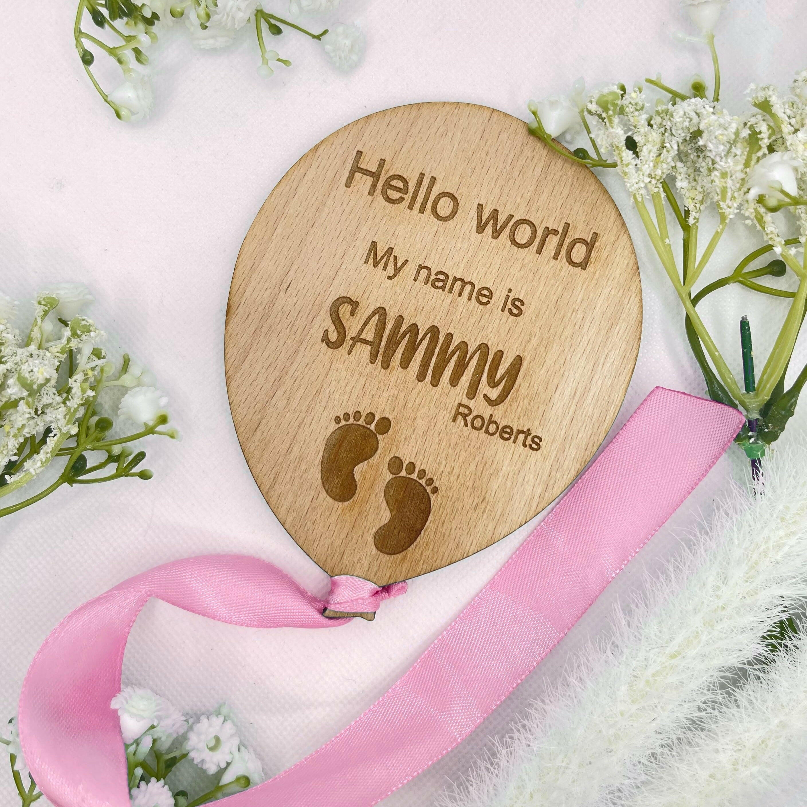 Handcrafted baby announcement plaque with a feet design and an elegant pink ribbon.