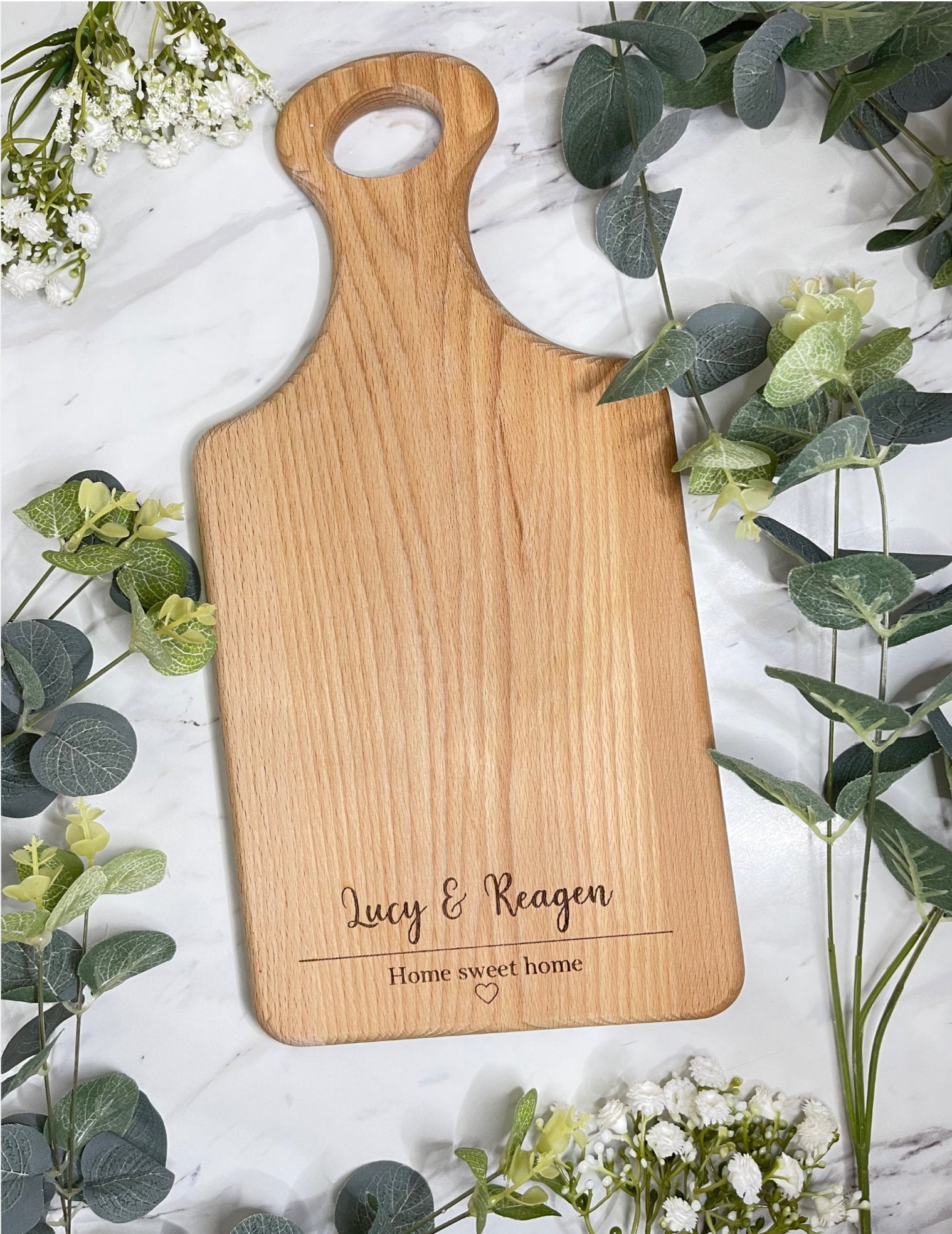 A personalised wooden serving board engraved with "Home Sweet Home," perfect as a housewarming gift.