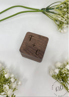 A personalised wooden wedding ring box engraved with the couple's initials.