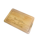 A full view of a personalised wooden chopping board with a heart and custom engraved text.